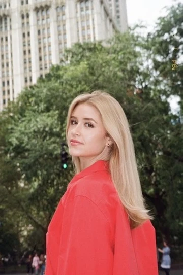Chloe looking over her shoulder in a bright red shirt outdoors